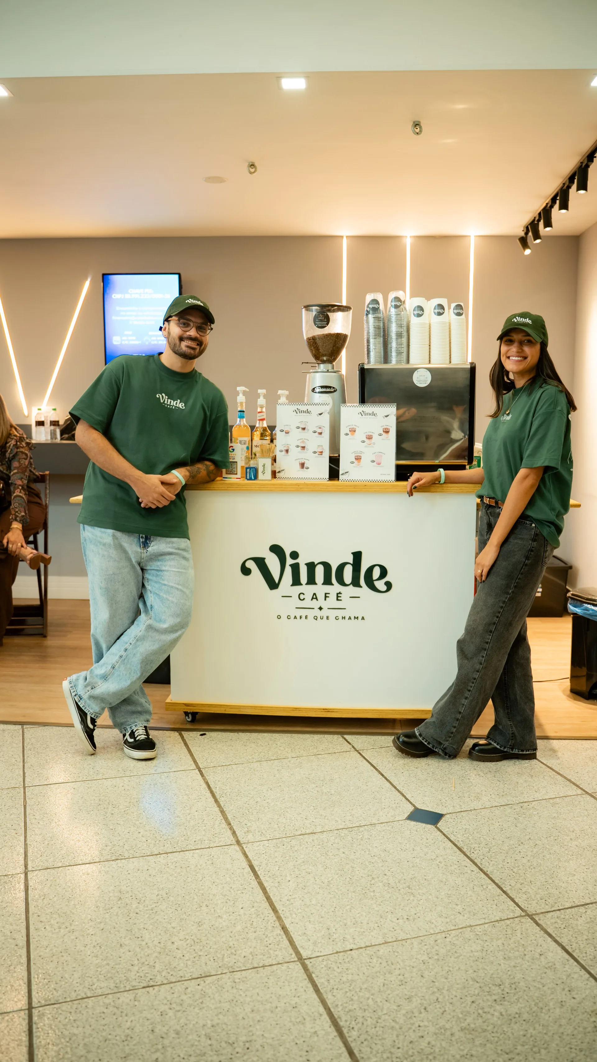 Coffee cart da Vinde Café montado num evento, com os fundadores Thiago e Giovanna ao lado